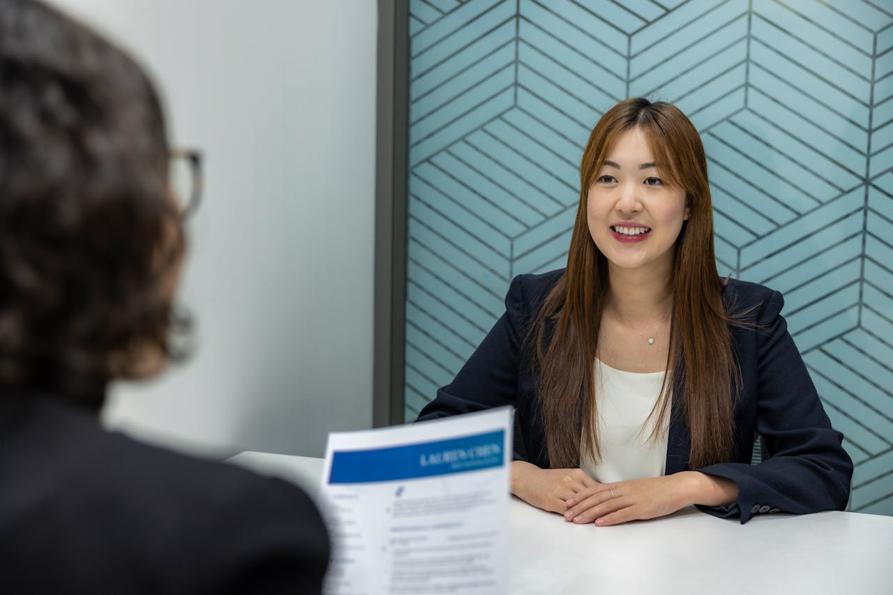 gallery-1 Young woman in a business meeting with an interviewer, showcasing confidence and professionalism.