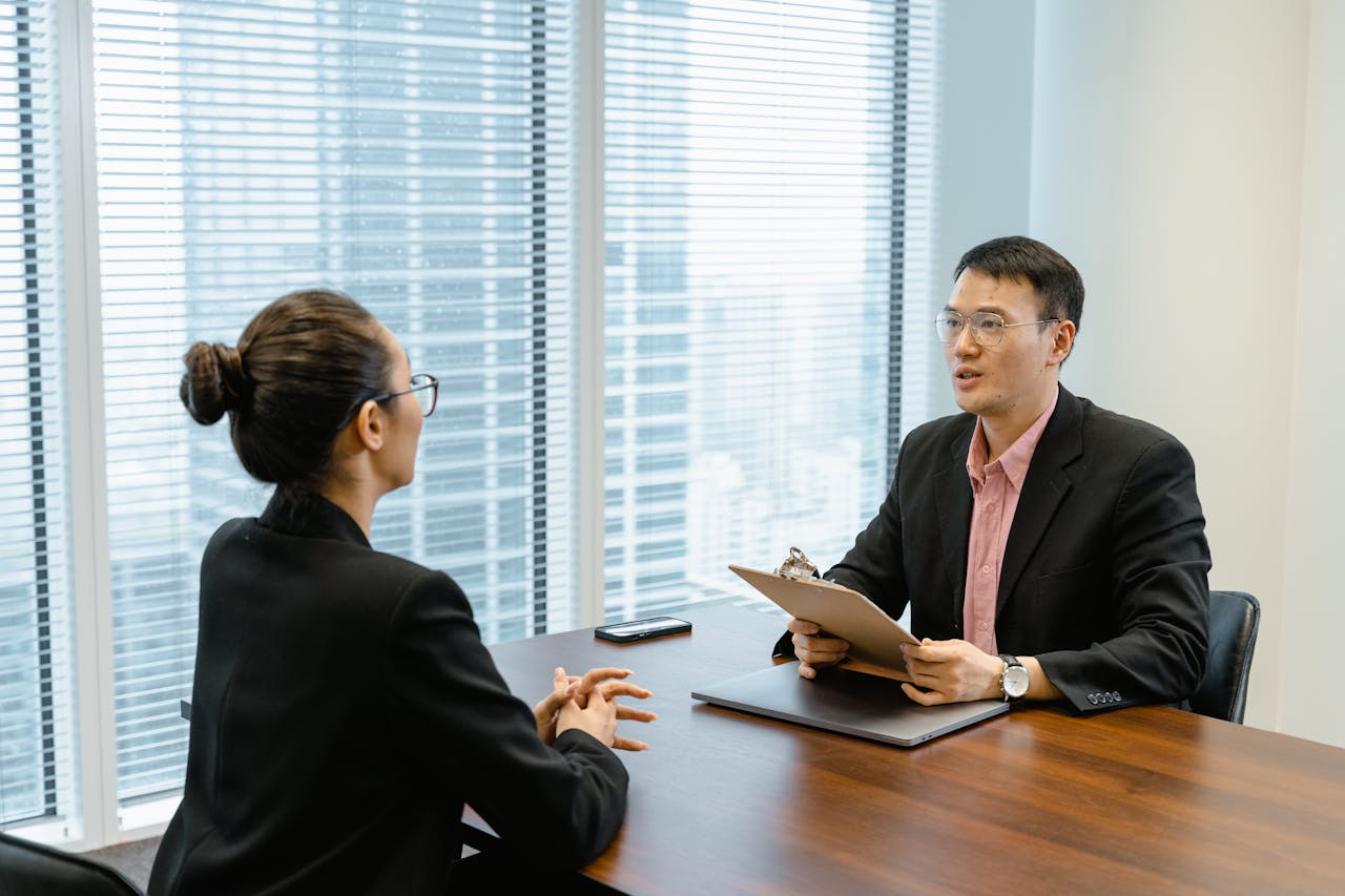 why-choose-us Professional business meeting in a modern office with two people discussing over documents.